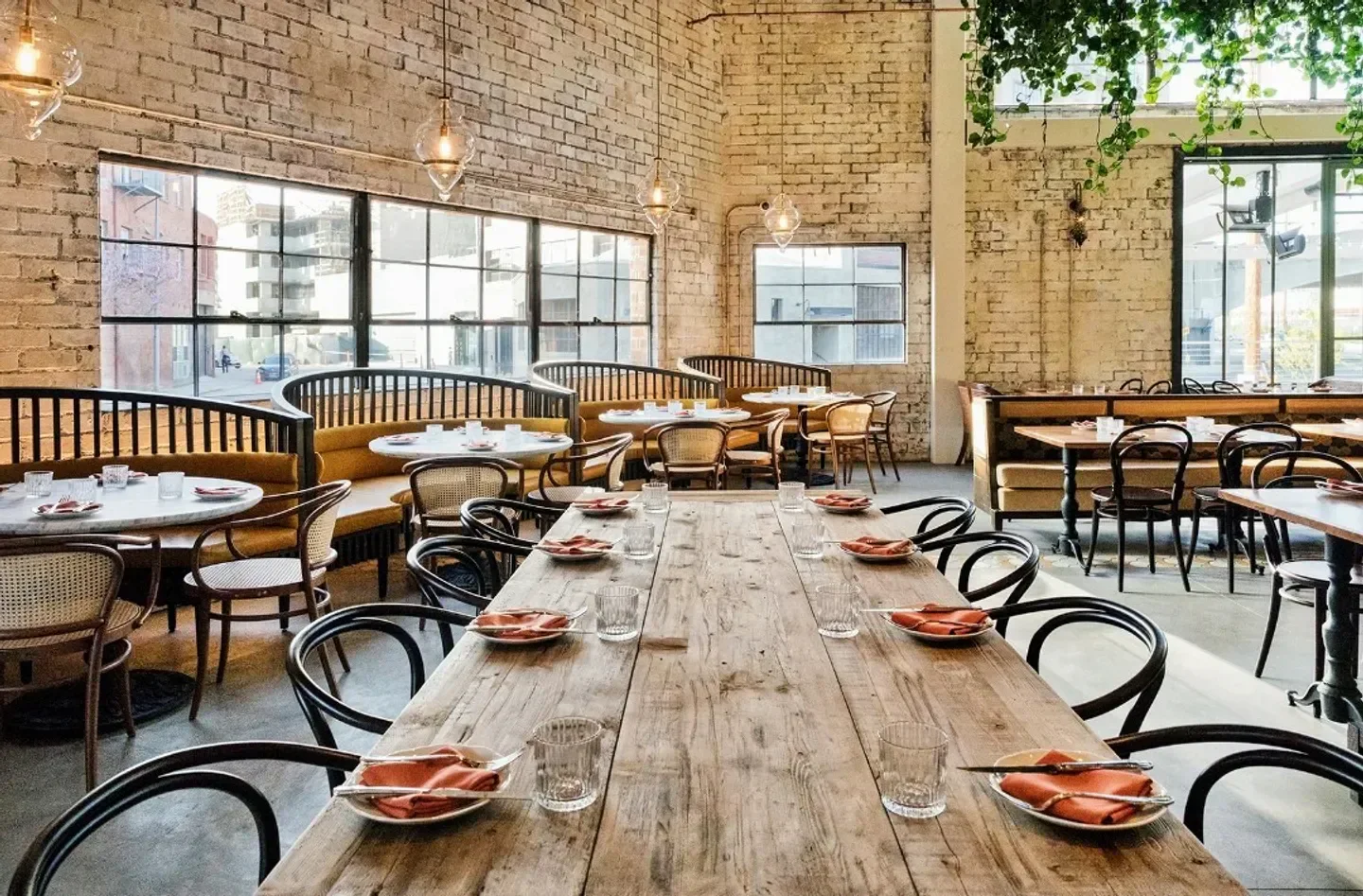 Interior of Bavel in Los Angeles with rustic wooden tables and stylish decor.