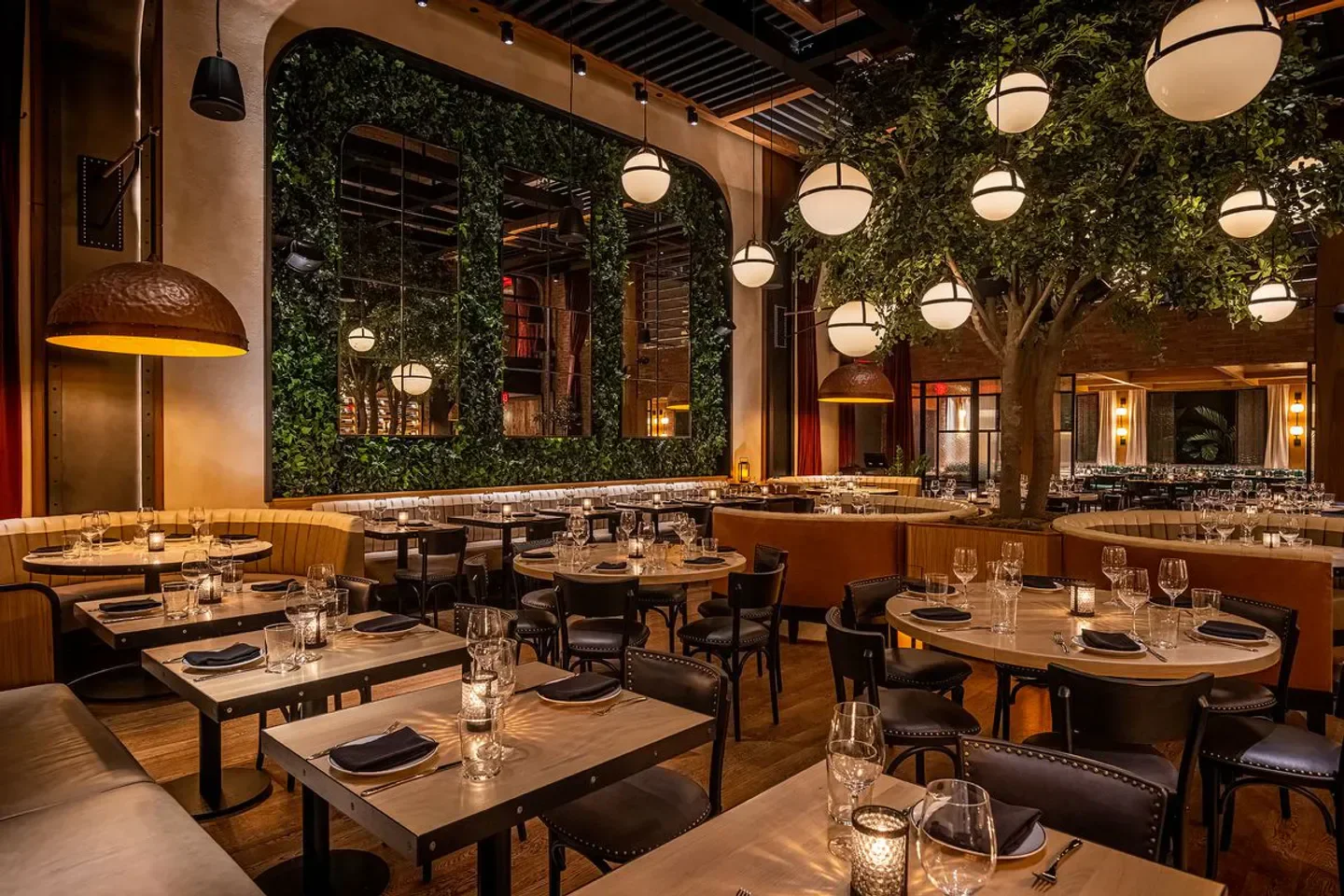 Interior of Catch Steak Los Angeles restaurant featuring a decorative tree and tables.