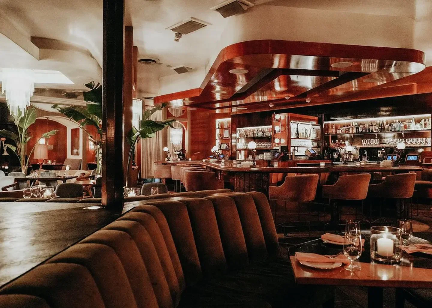 Interior of Delilah Los Angeles restaurant with a bar, cozy seating, and elegant ambiance.