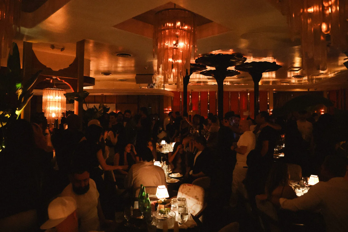 Warm, ambient lighting illuminates the lively interior of Delilah nightclub, with patrons enjoying the atmosphere.