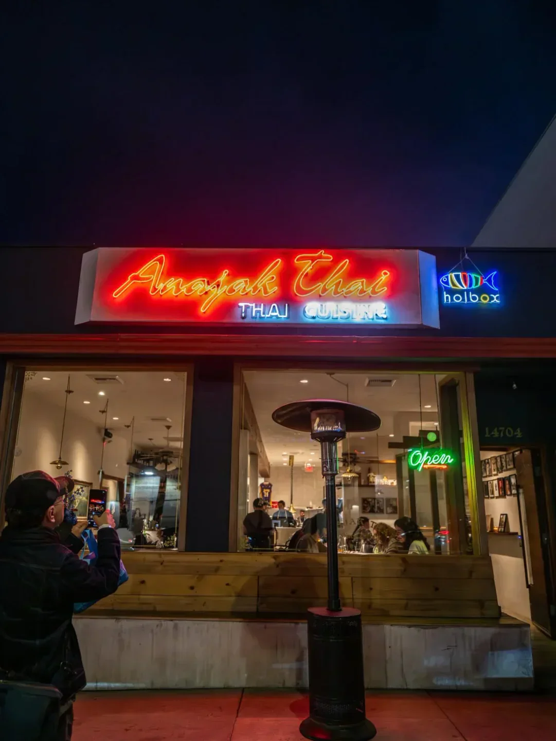 Neon signs at Holbox restaurant in Los Angeles, inviting people to dine inside