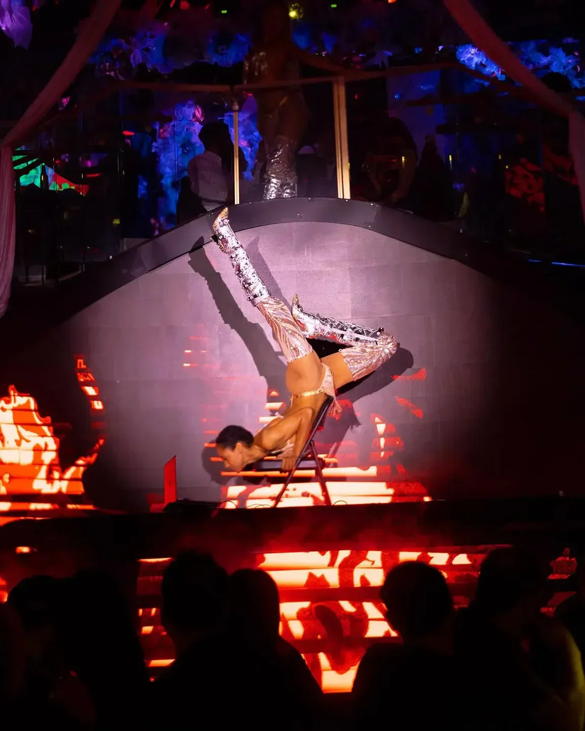 Acrobatic performer at MainRo nightclub in Los Angeles with colorful stage lighting.