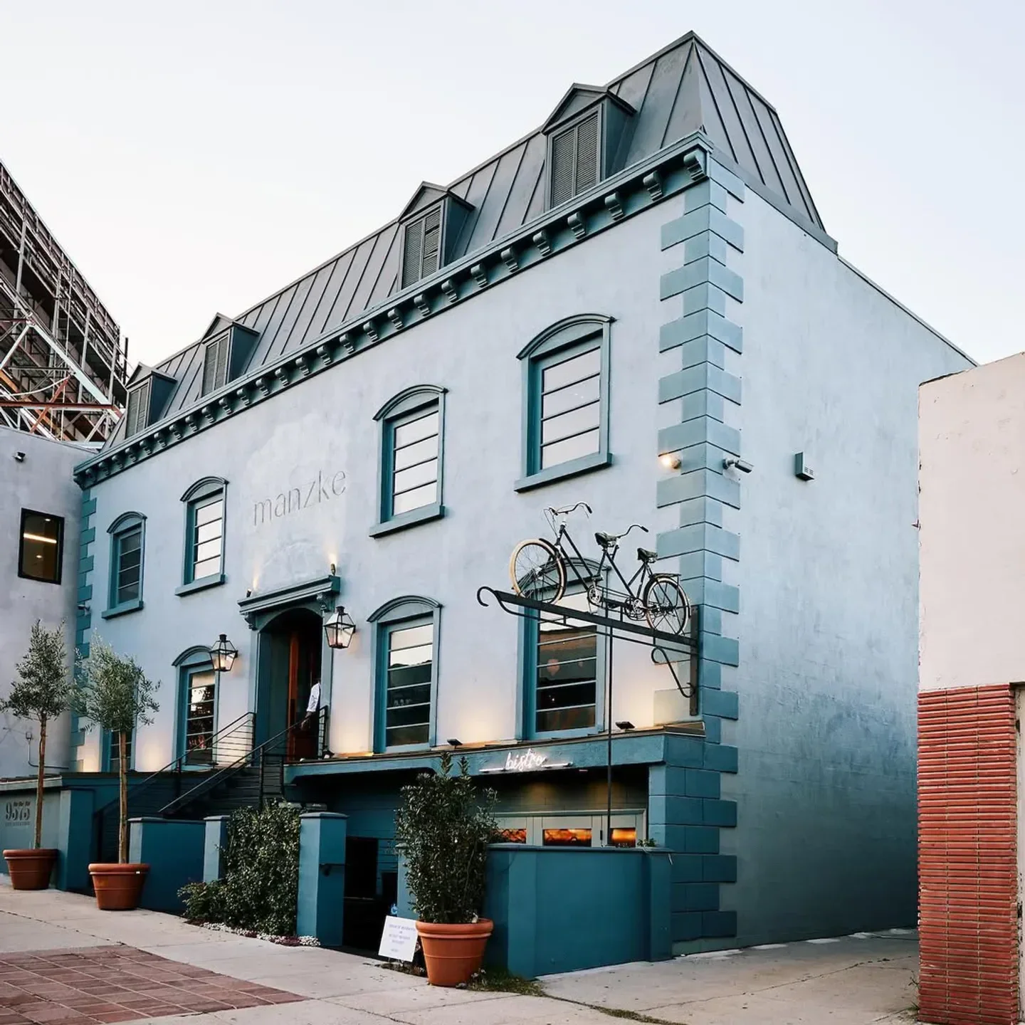 Exterior view of Manzke restaurant in Los Angeles, featuring bicycle decor and bistro sign