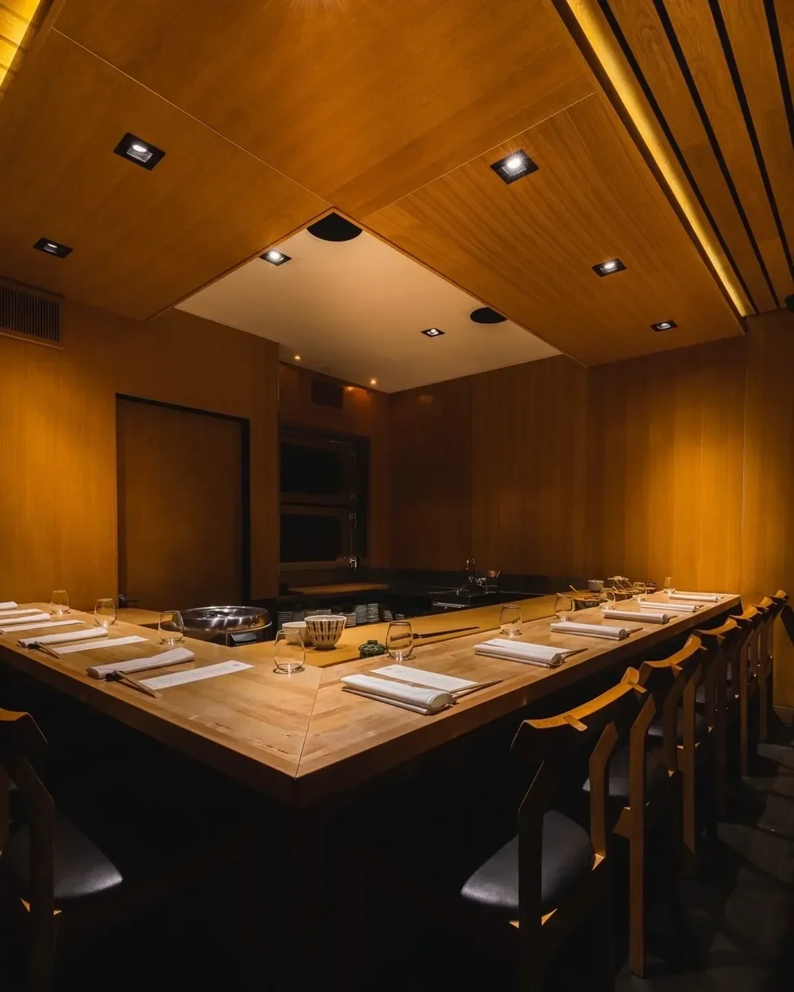 Elegant dining space at Nozawa Bar in Los Angeles, featuring a sushi counter and wooden interior.