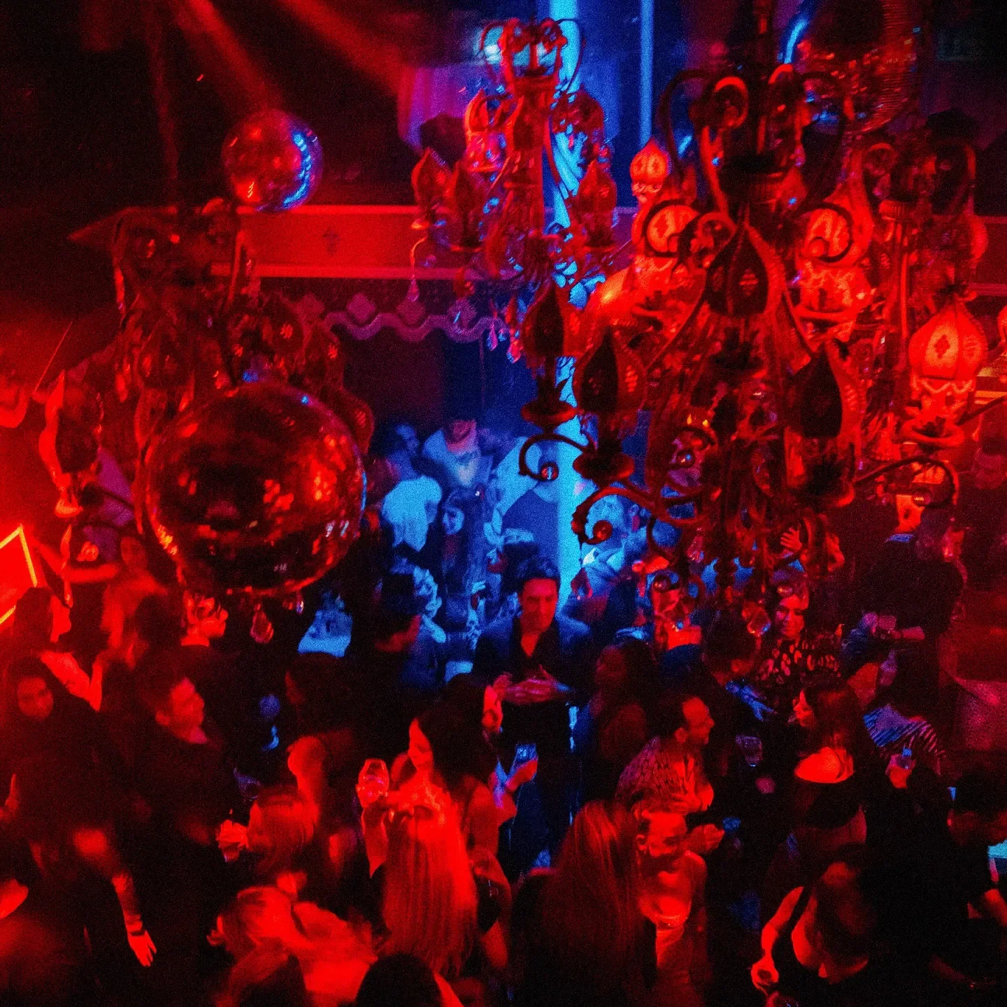 Inside Raspoutine Los Angeles: Red and blue lights illuminate the restaurant's lively atmosphere.