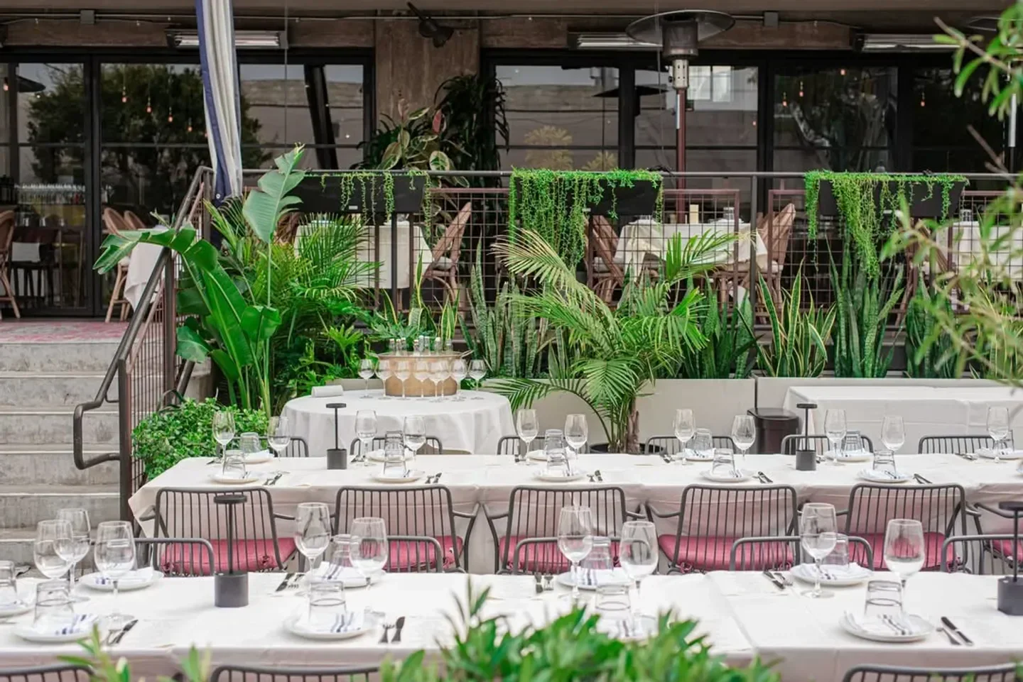 Outdoor dining at Rossoblu restaurant in Los Angeles, set with elegant tables and plants.