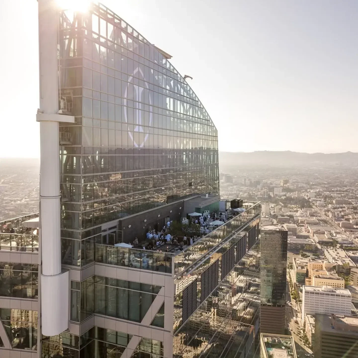 Aerial view of Spire 73 restaurant in Los Angeles with city skyline and guests.