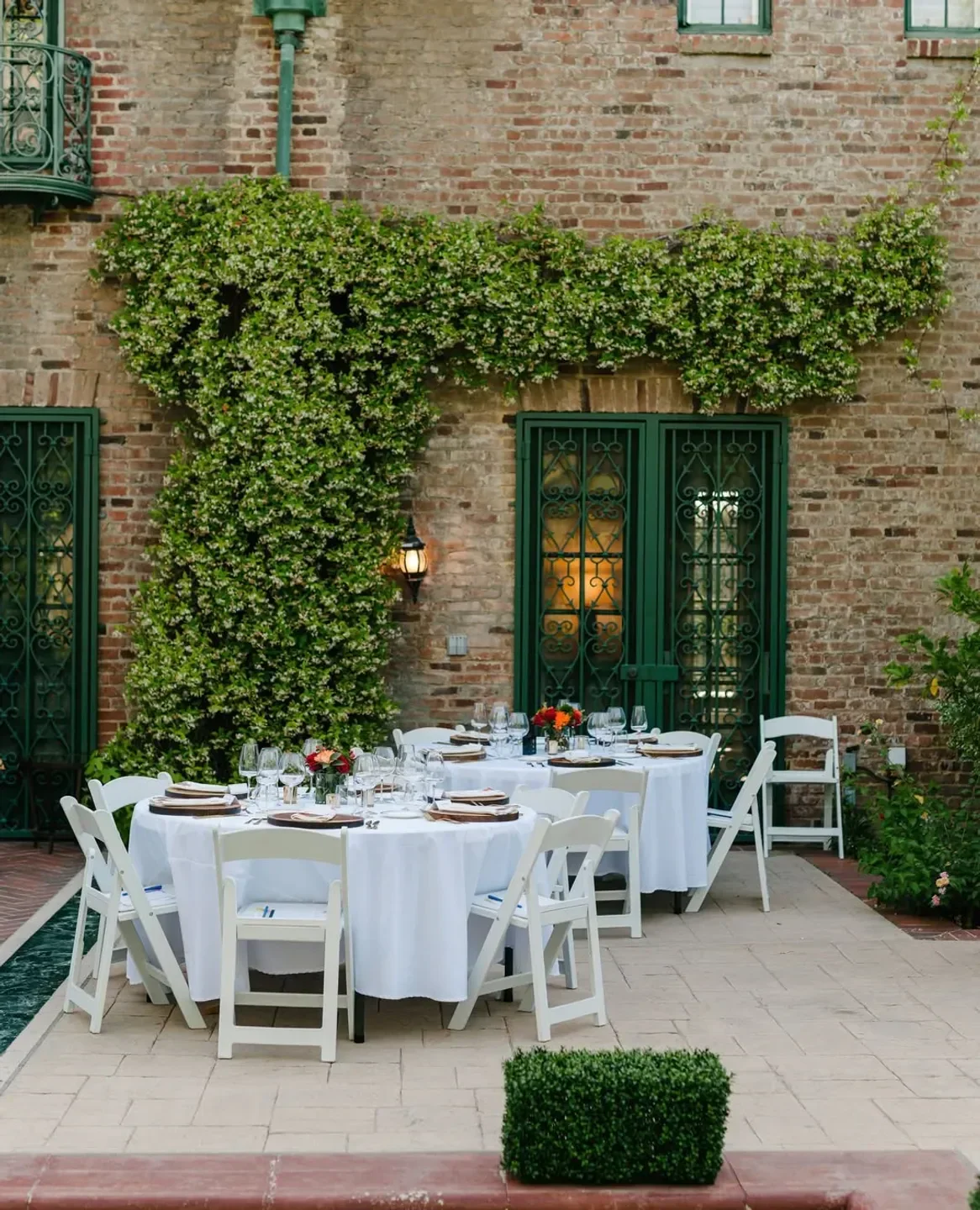 Outdoor dining at Stella in Los Angeles, with a brick wall and green decor