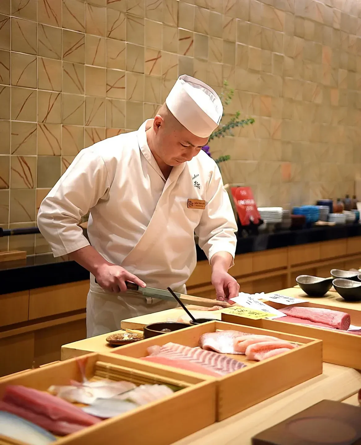 Chef preparing sushi at Sushi Ginza Onodera in Los Angeles, showcasing fresh ingredients.