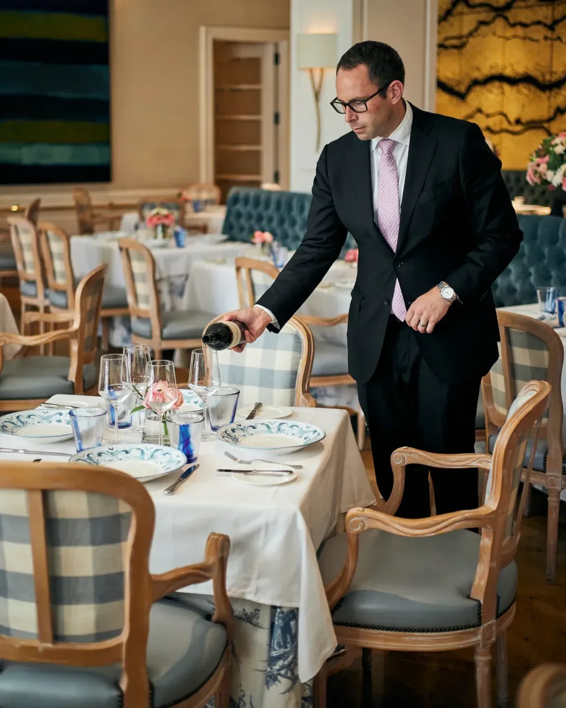 Server pours wine at The Belvedere restaurant in Los Angeles, elegant dining setting