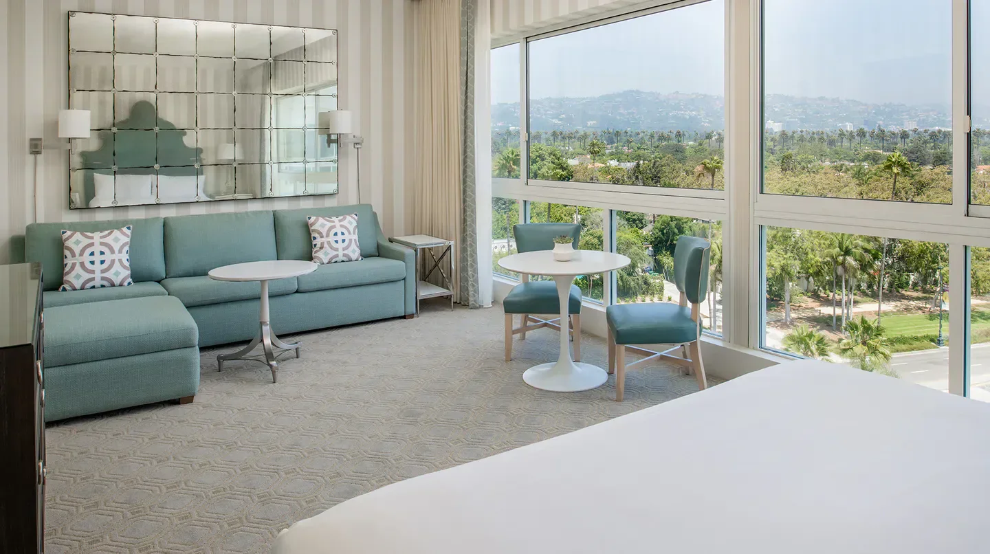 Spacious hotel room at The Beverly Hilton in Los Angeles with city views.