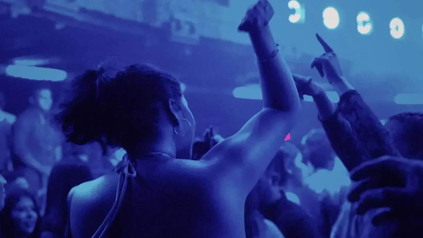 Dancing crowd at The Mayan nightclub in Los Angeles with raised arms and excitement