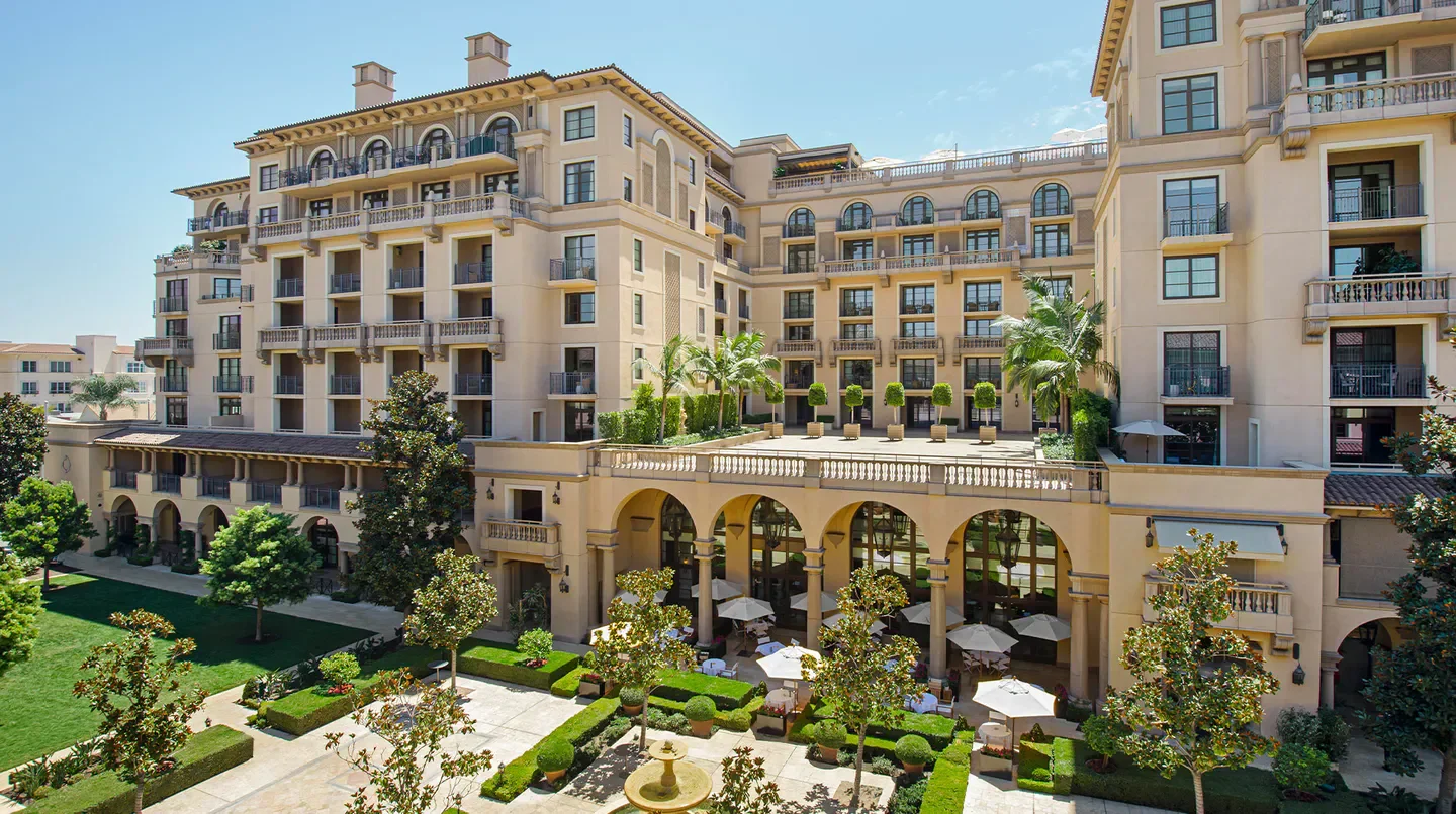 Exterior of The Maybourne Beverly Hills in Los Angeles, featuring elegant architecture and lush landscaping